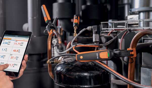 L’instrument 115i et 549i de Testo, installé sur un système de chauffage et commandé au moyen d’un téléphone intelligent
